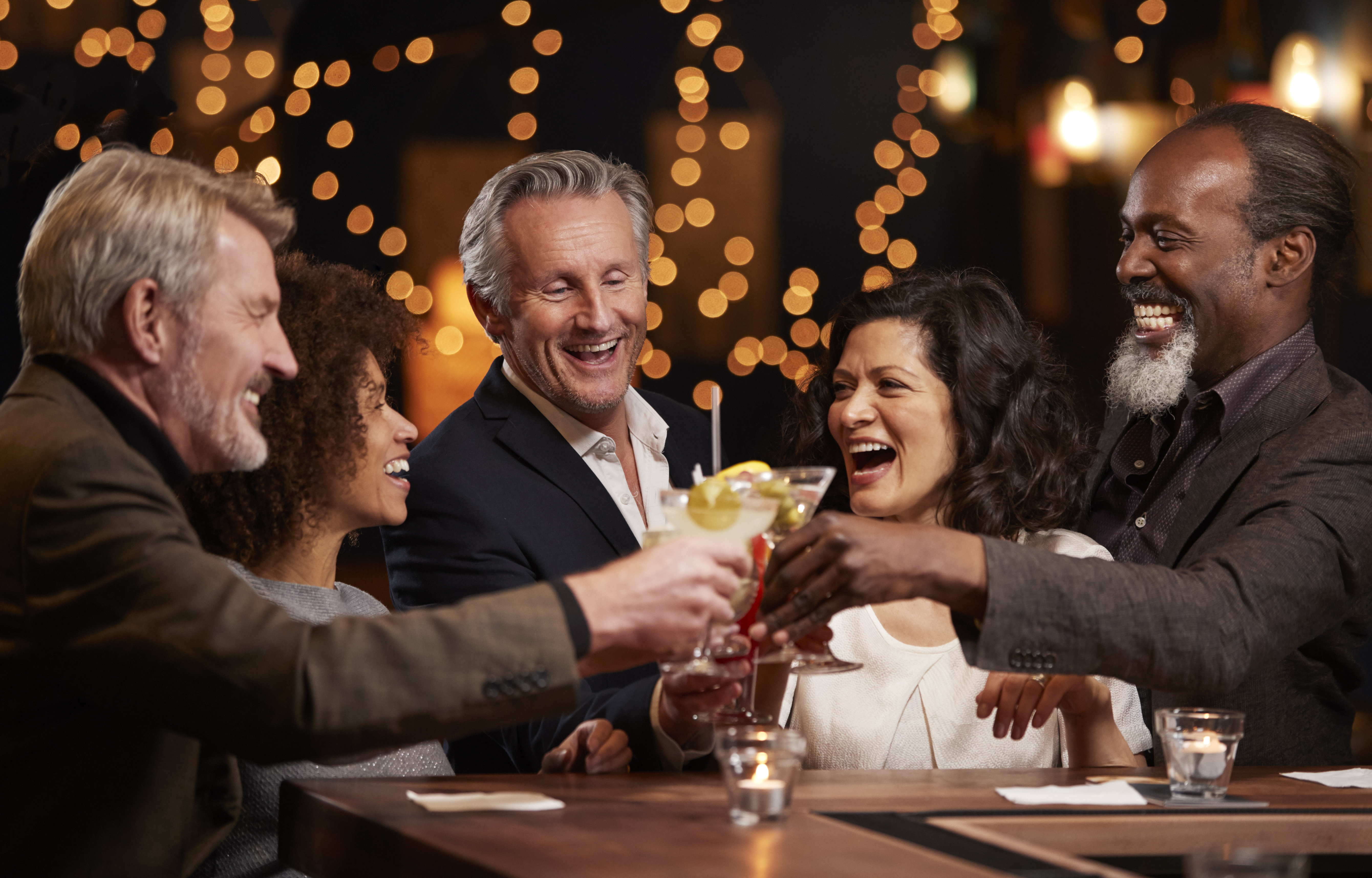Group with drinks celebrating in bar