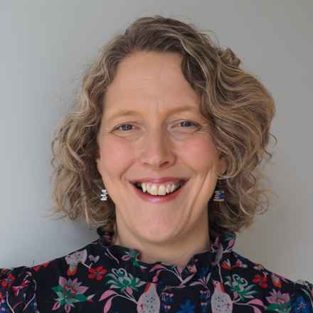 Close up portrait of Professor Ruth Hogg, smiling.