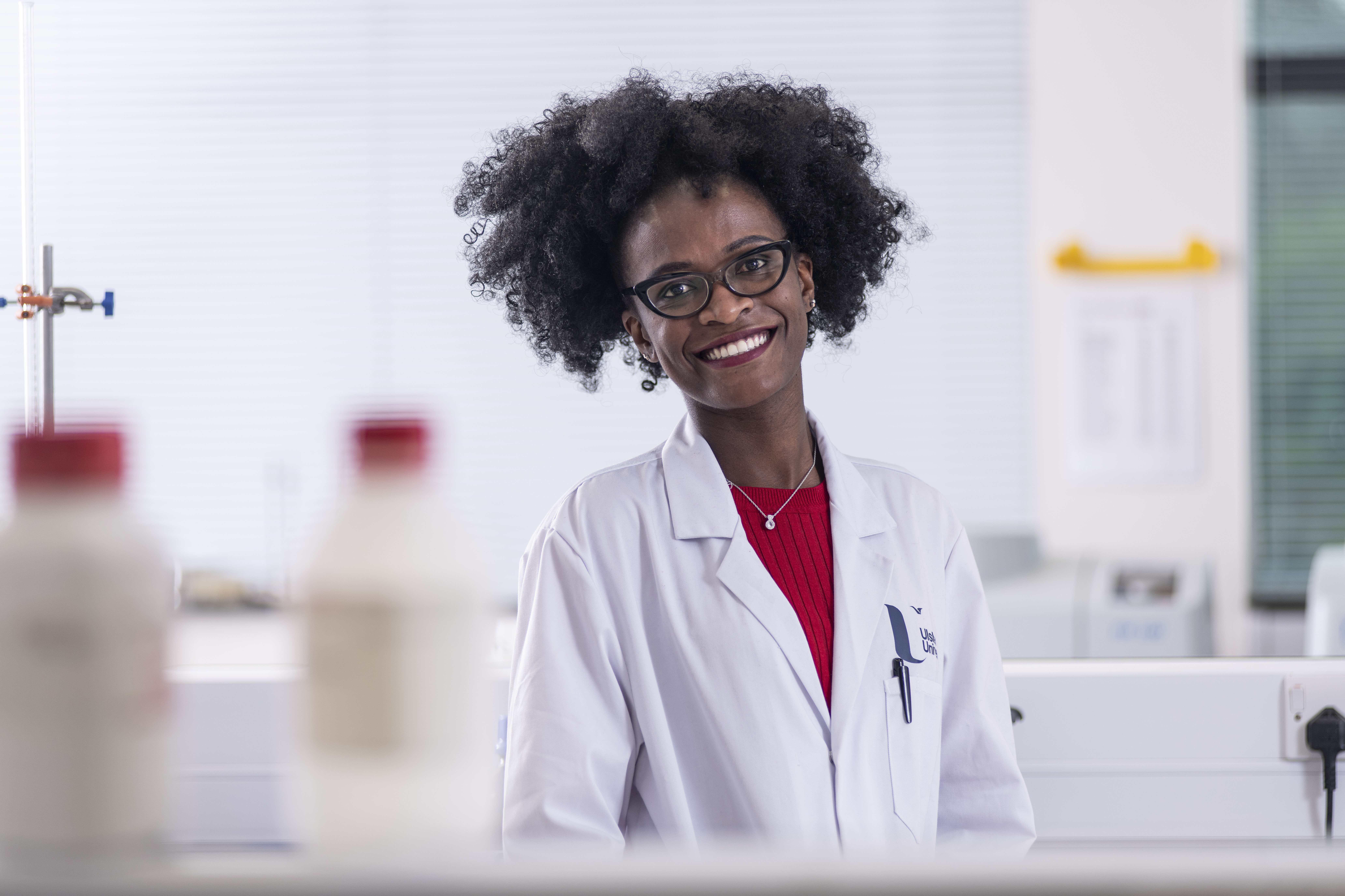 Oduor Poullette smiling in white lab coat 