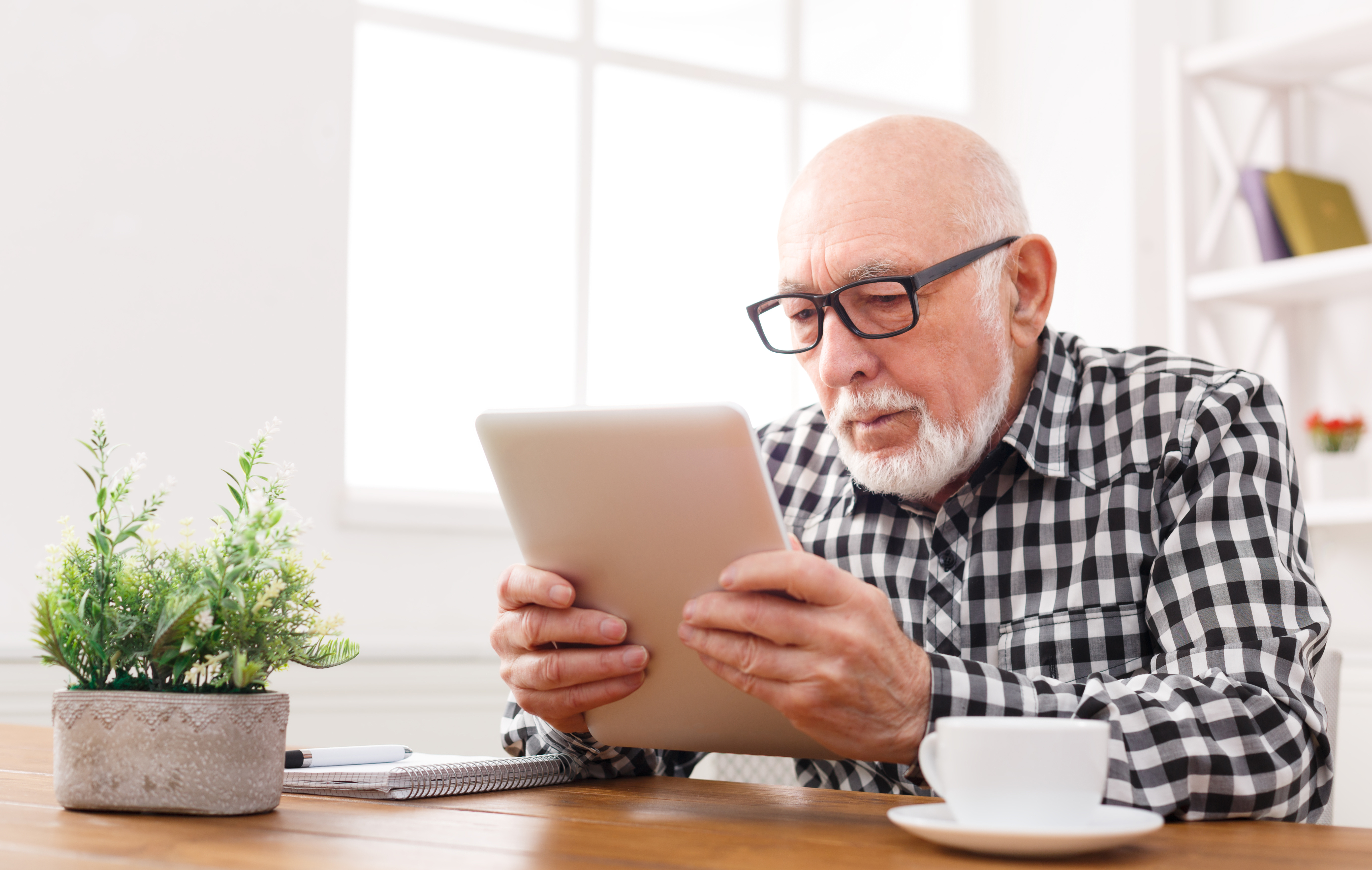 Man with glasses, looking at tablet