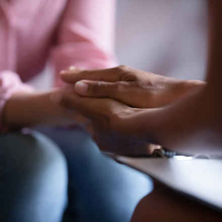 Person holding another's hand to reassure them